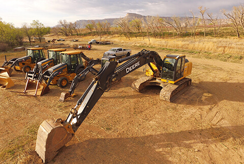 Excavators and loader backoes lined up